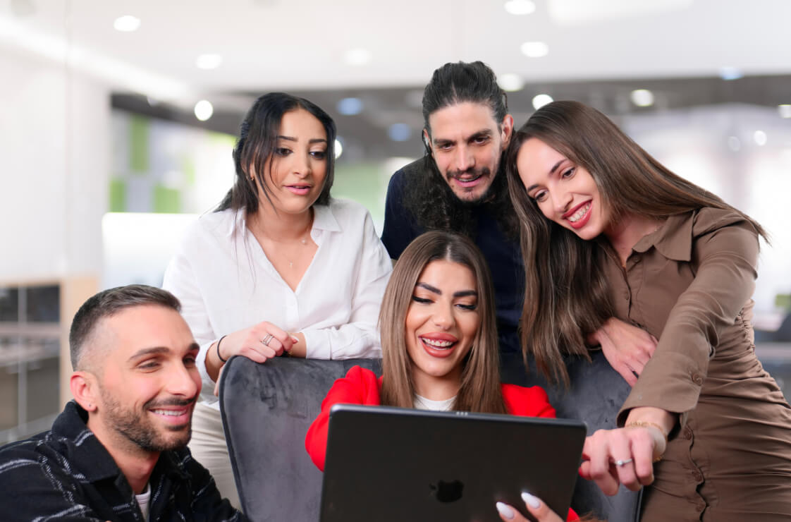 Un grupo de profesionales de la empresa colabora en un ordenador portátil para mejorar la productividad y el trabajo en equipo.