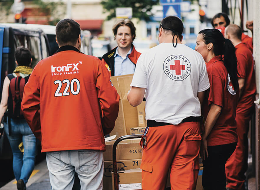 Voluntarios de la Cruz Roja y de IronFx prestando asistencia y apoyo a los necesitados.