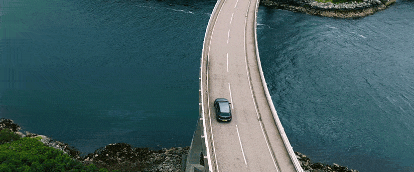 A Volkswagen car driving on a bridge over water