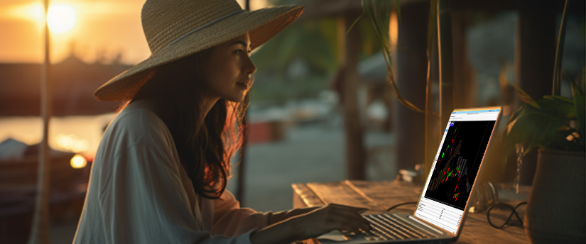 Una mujer con sombrero está trabajando con su ordenador portátil, concentrada en la pantalla.