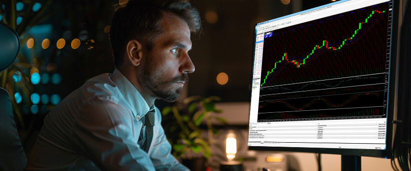 A man focuses on a computer screen featuring an MT4 indicator for trading analysis.